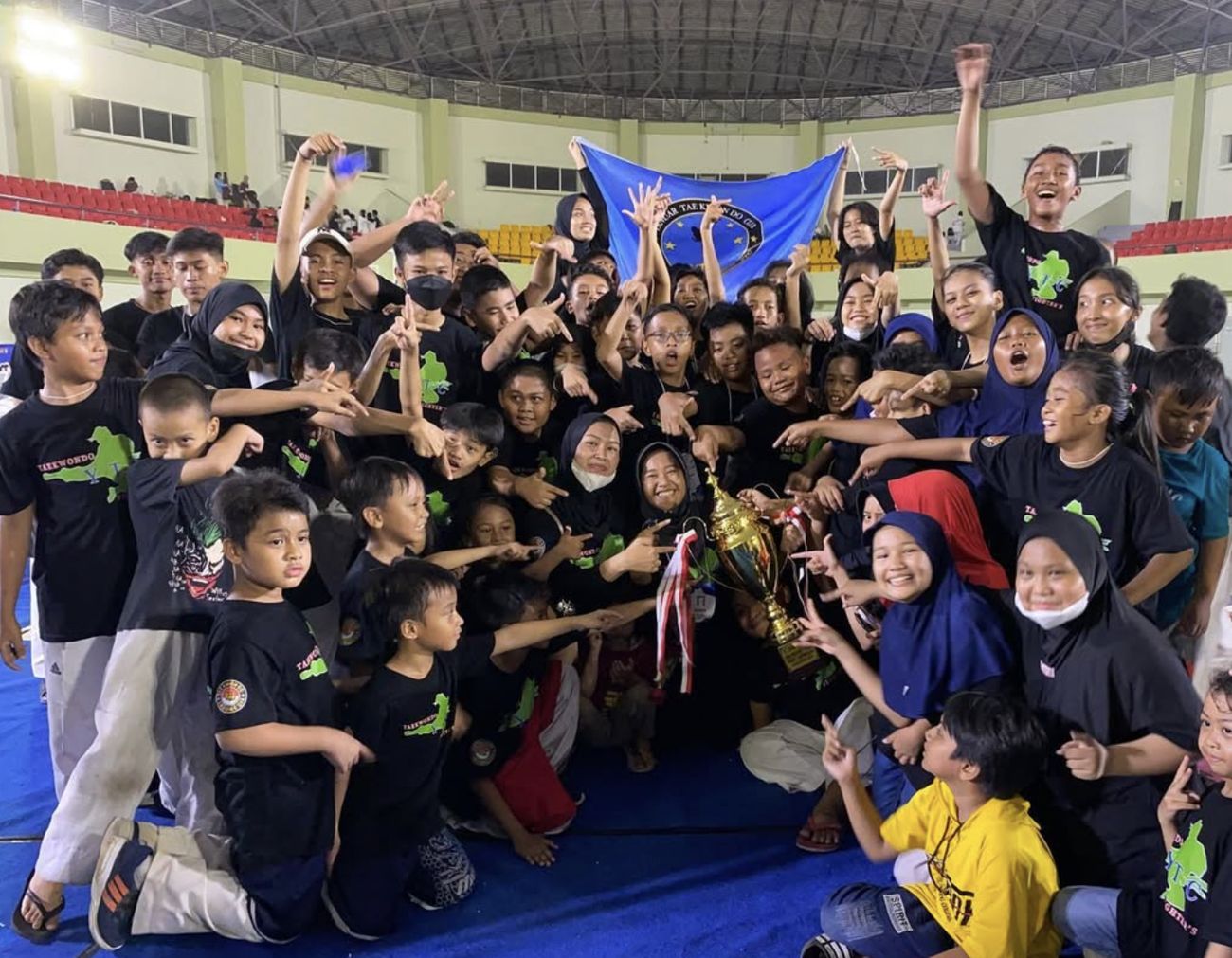 Tim RAP Fighters / YTC Fighters merayakan juara dengan trofi di kejuaraan taekwondo